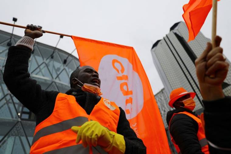 Des travailleurs tiennent des drapeaux du syndicat CFDT lors d'une manifestation à Paris