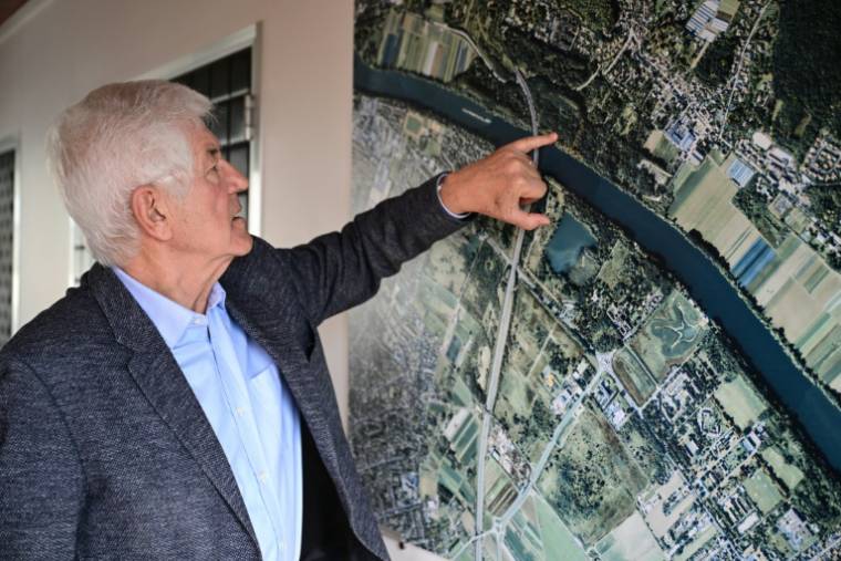 le maire du Mesnil-Le-Roi (DVD), Serge Caseris montre l'emplacement de la "Villa Sapène" sur la carte d'une vue aérienne de la commune, le 24 avril 2024 dans les Yvelines ( AFP / MIGUEL MEDINA )