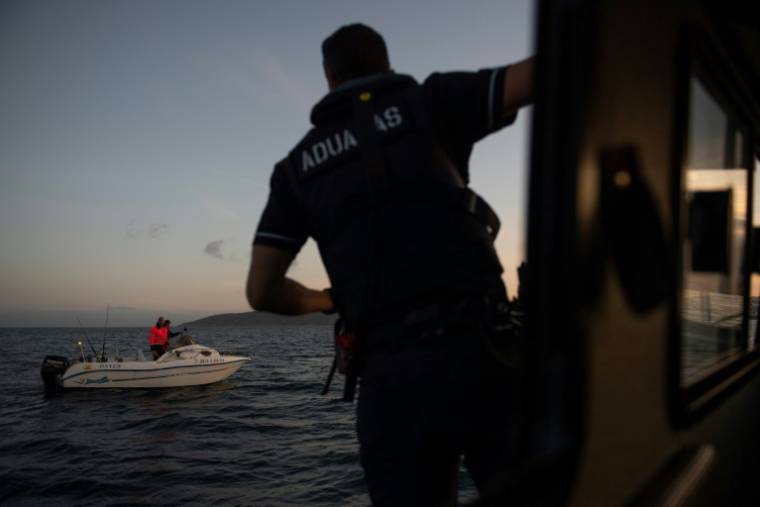 Un membre du service maritime espagnol Aduanas surveille les eaux depuis son bateau dans le détroit de Gibraltar, près d'Algeciras, le 9 avril 2024 dans le sud de l'Espagne ( AFP / JORGE GUERRERO )