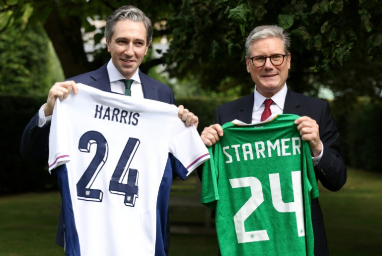 Les Premiers ministres irlandais Simon Harris (d) et britannique Keir Starmer échangent les maillots de football de leurs équipes nationales respectives, le 7 septembre 2024 à Dublin ( POOL / Peter Morrison )