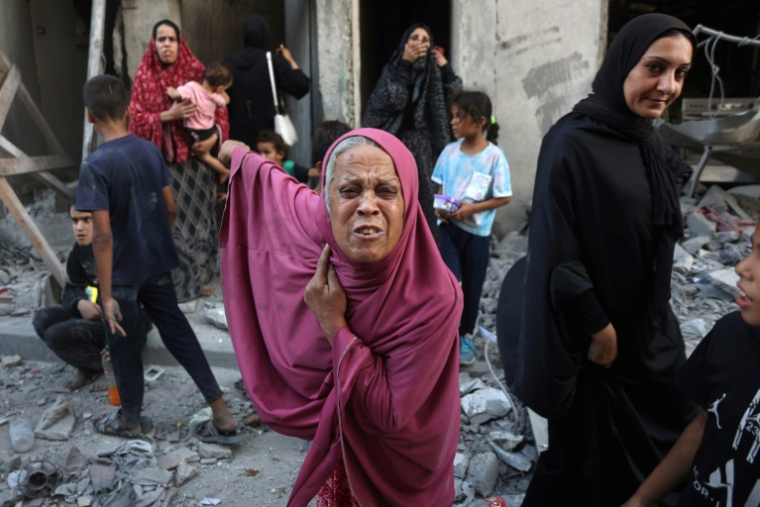 Des Palestiniens inspectent les dégâts causés par des bombardements dans la ville de Gaza, le 11 août 2024 ( AFP / Omar AL-QATTAA )