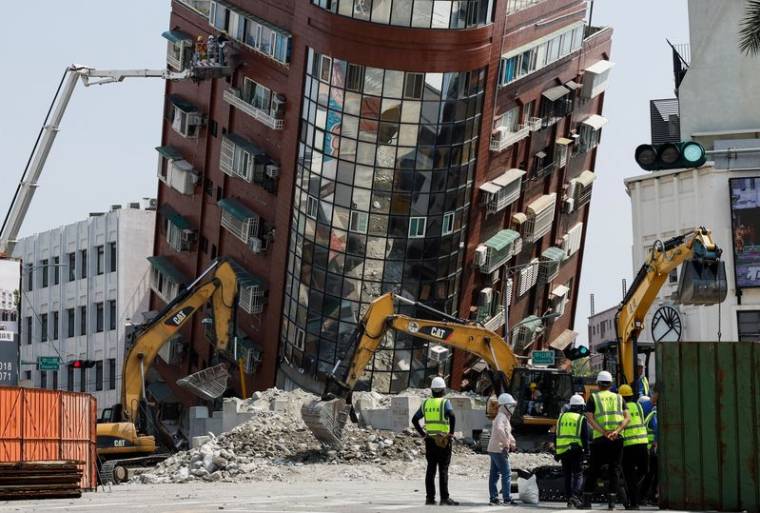 Des ouvriers interviennent sur le site où un bâtiment s'est effondré, suite au tremblement de terre, à Hualien
