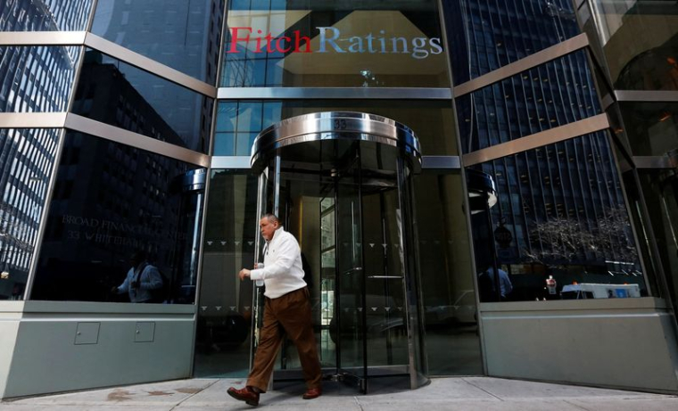 Des personnes passent devant le siège de Fitch Ratings à New York