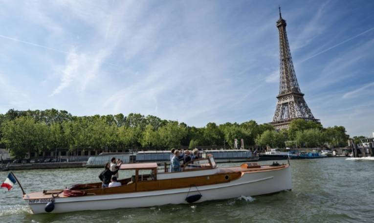 Des visiteurs à bord d'un "taxi Seine Paris", le 13 juin 2024 à Paris ( AFP / BERTRAND GUAY )