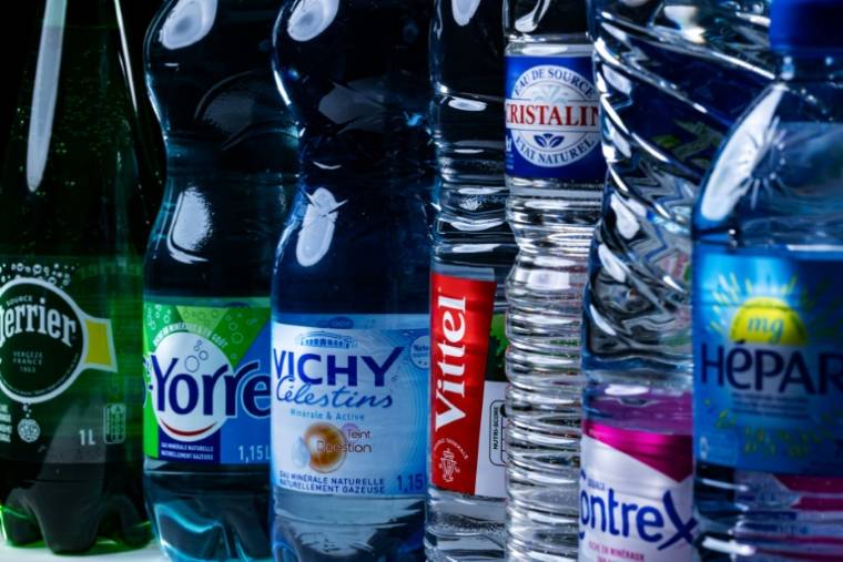 Des bouteilles d'eau minérale de marques appartenant au groupe Nestlé Waters, le 21 février 2024 à Paris ( AFP / JOEL SAGET )
