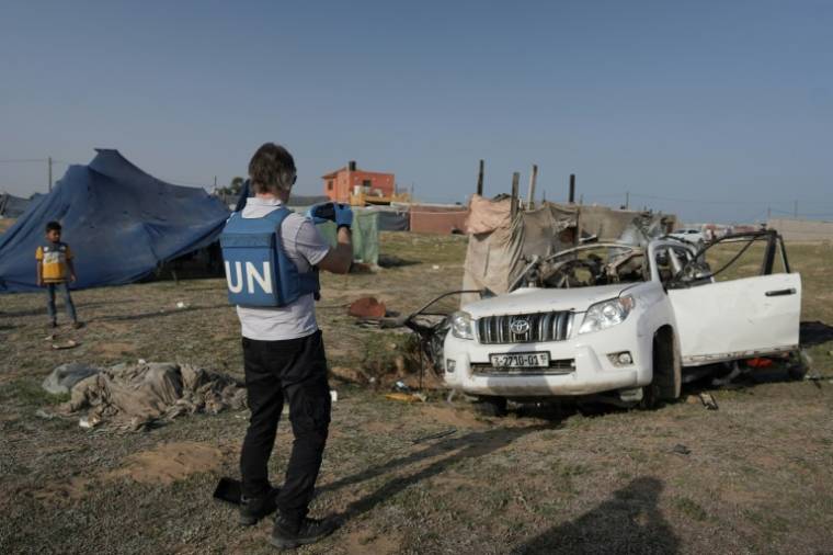 Des membres du personnel des Nations Unies inspectent la voiture dans laquelle voyageaient des humanitaires étrangers, tués par une frappe israélienne, le 2 avril 2024 à Deir al-Balah, dans la bande de Gaza ( AFP / - )