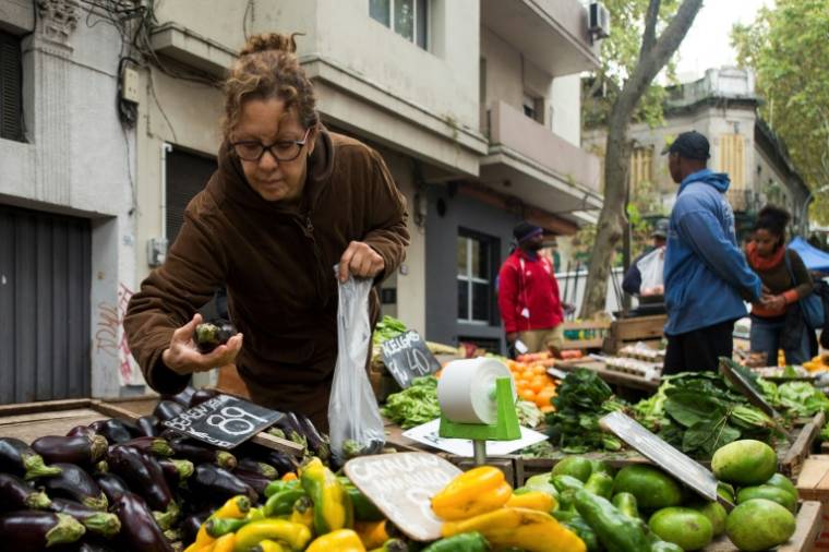 Une habitante achète des légumes sur un marché à Montevideo, le 23 avril 2024 en Uruguay ( AFP / Pablo VERA )