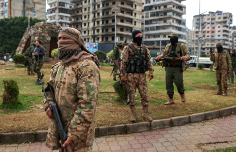 Des combattants affiliés à la nouvelle administration syrienne montent la garde dans les rues de la ville côtière de Lattaquié, dans l'ouest de la Syrie, le 26 décembre 2024 ( AFP / AAREF WATAD )