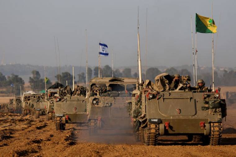 Un convoi israélien de chars et de véhicules blindés de transport de troupes passe la frontière israélienne