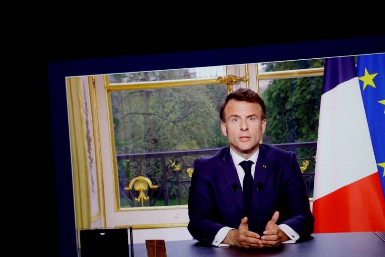 Le président français Emmanuel Macron apparaît sur un écran, alors qu'il s'exprime lors d'un discours