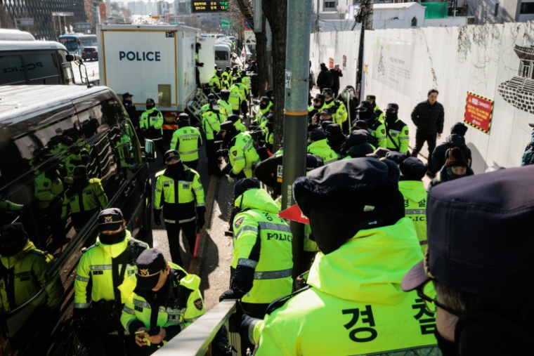 Des policiers devant la résidence du président sud-coréen déchu Yoon Suk Yeol après son arrestation, le 15 janvier 2025 à Séoul ( AFP / YASUYOSHI CHIBA )