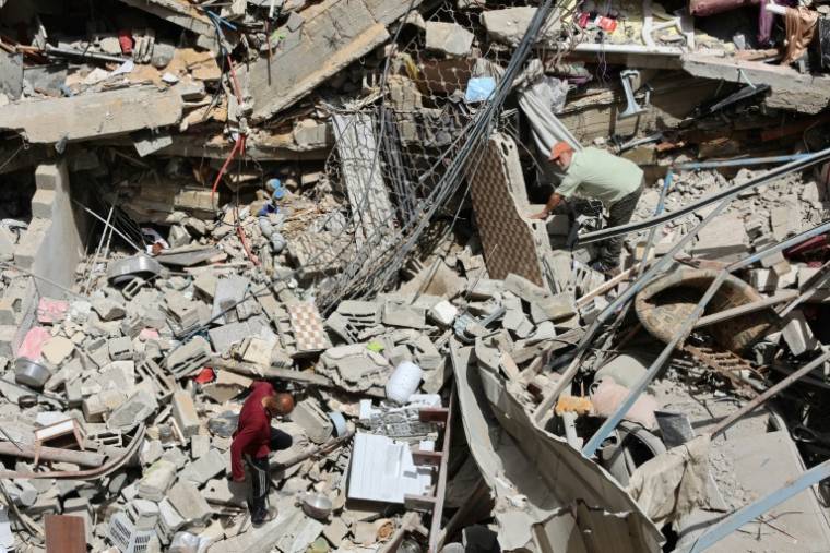 Des Palestiniens fouillent les décombres d'un bâtiment touché par des frappes israéliennes dans le quartier d'Al-Daraj, à Gaza, le 23 mai 2024 ( AFP / Omar AL-QATTAA )