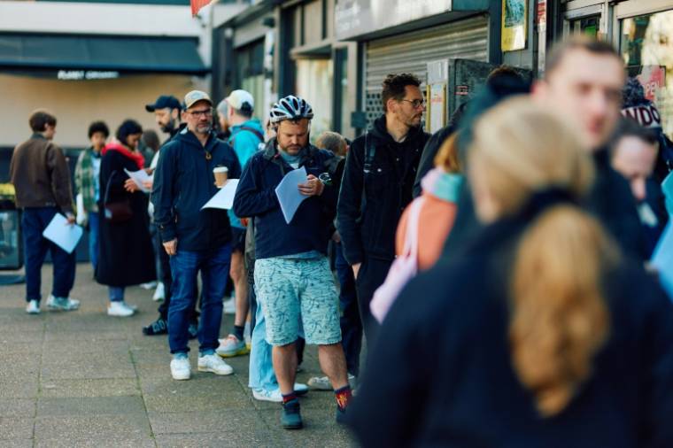 Des clients font la queue devant la boutique de vinyles Flashback Records, le 18 avril 2024 à Londres  ( AFP / BENJAMIN CREMEL )