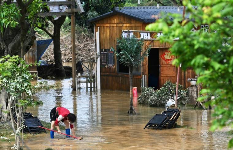 Nettoyage de la boue et des dégâts après des inondations à Qinguyan, dans la province du Guangdong, le 24 avril 2024 dans le sud de la Chine ( AFP / HECTOR RETAMAL )