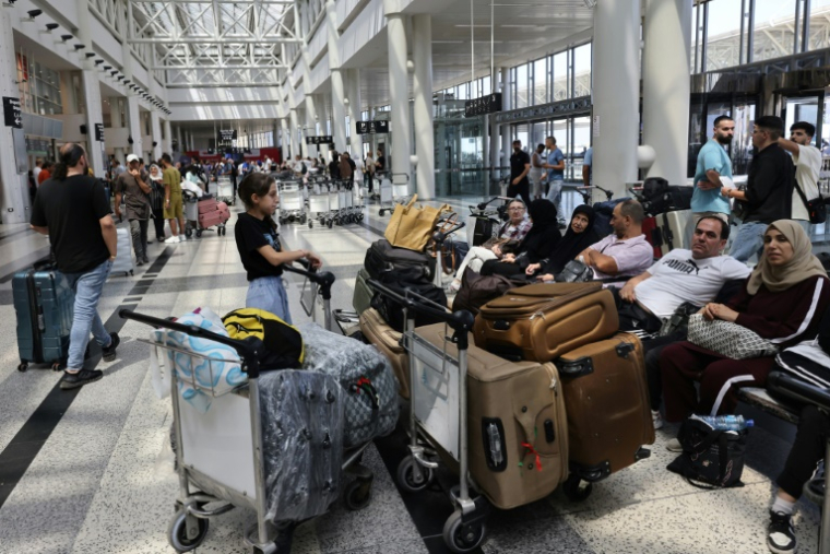 Des voyageurs attendent un avion à l'aérport international de Beyrouth, le 25 septembre 2024 auLiban ( AFP / ANWAR AMRO )