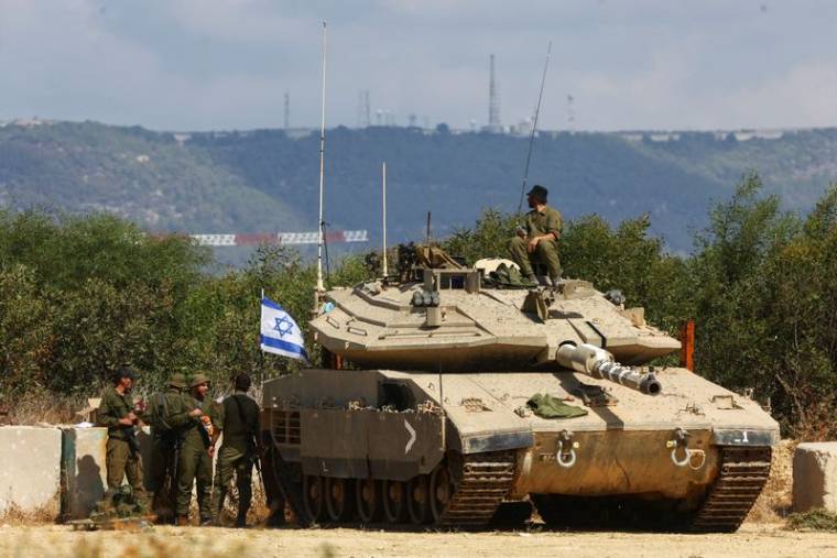 Des soldats israéliens près d'un char près de la frontière israélienne avec le Liban