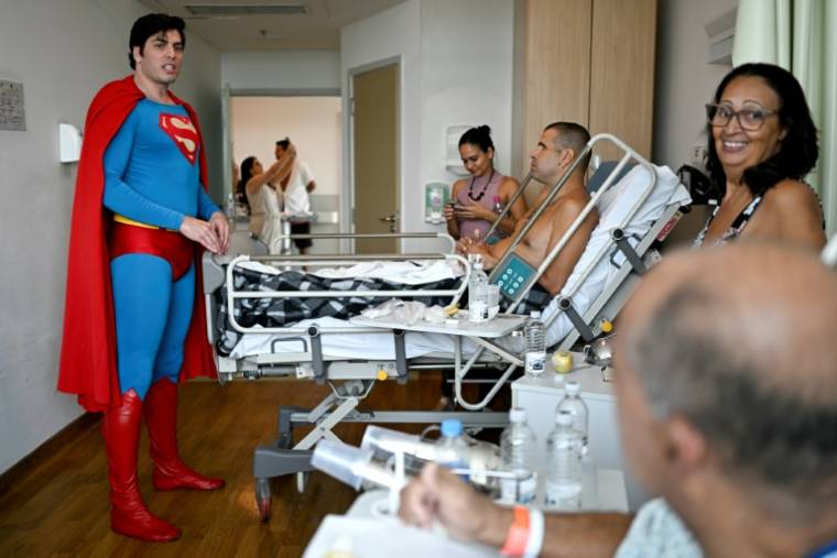 Leonardo Muylaert, le "Superman brésilien",  avec des patients et des membres l'équipe médicale de l'Institut de traumatologie et d'orthopédie (Into), le 18 mars 2024 à Rio de Janeiro ( AFP / MAURO PIMENTEL )