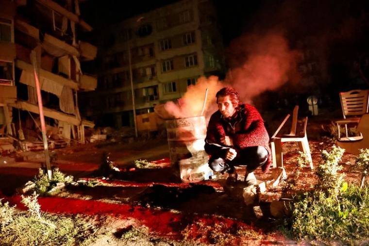 Un homme près des bâtiments endommagés après un tremblement de terre à Antakya, en Turquie