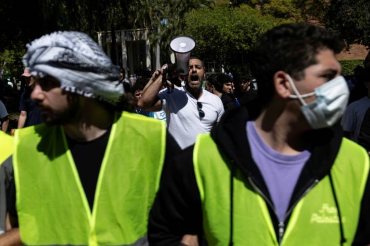 Un manifestant pro-israélien crie dans un mégaphone au cours d'une manifestation sur le campus de l'Université de Californie à Los Angeles (UCLA) le 28 avril 2024 ( AFP / Etienne LAURENT )
