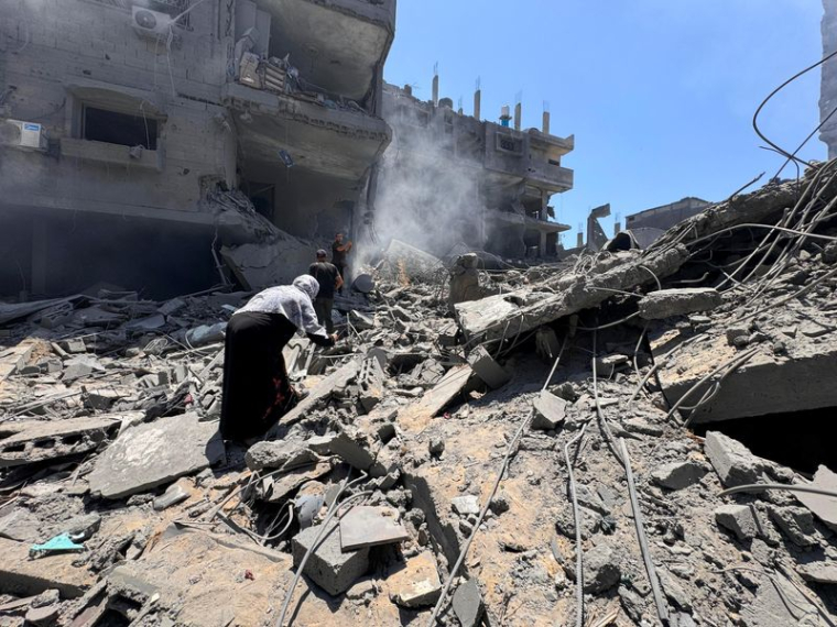 Palestinians search for casualties at the site of Israeli strikes on houses