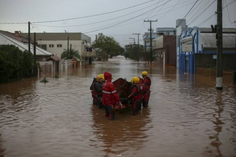 Des pompiers dans une rue inondée de Sao Sebastiao do Cai, dans l'Etat du Rio Grande do Sul, le 2 mai 2024 au Brésil ( AFP / Anselmo Cunha )
