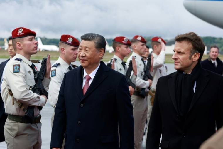 Le président Emmanuel Macron (d) accueille son homologue chinoix Xi Jinping à son arrivée à l'aéroport de Tarbes, début d'une visite dans les Pyrénées, le 7 mai 2024 ( POOL / Aurelien Morissard )
