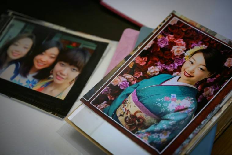 Photos of Narumi Kurosaki are displayed on the desk of his family's lawyer, Me Sylvie Galley, on the first day of Nicolas Zepeda's appeal trial, December 4, 2023 in Vesoul (AFP / Sebastien Bozon)