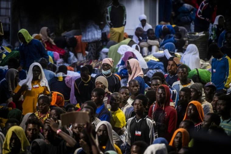 Des migrants attendent devant le centre d'accueil de Lampedusa, le 14 septembre 2023 en Italie ( AFP / Alessandro Serranò )