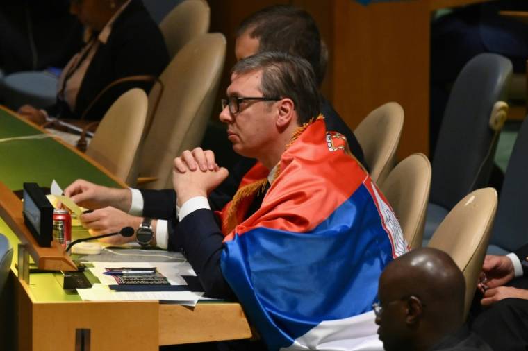 Le président de la Serbie Aleksandar Vucic porte un drapeau serbe lors du vote à l'Assemblée générale de l'ONU sur la création d'une Journée de commémoration du génocide de Srebrenica, le 23 mai 2024 ( AFP / ANGELA WEISS )