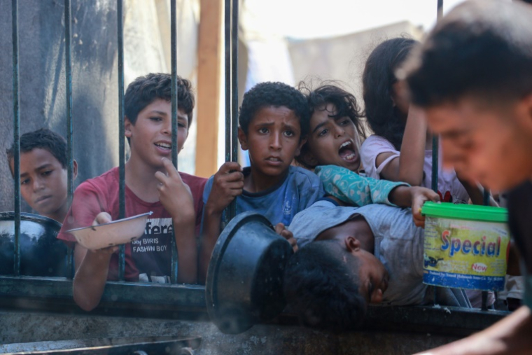 Des enfants palestiniens attendent de recevoir des rations de nourriture dans le camp de déplacés d'al-Mawassi dans le sud de la bande de Gaza, le 3 septembre 2024 ( AFP / Bashar TALEB )