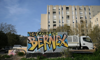 Un graffitt peint sur un mur indiquant l'emplacement d'un trafic de drogue (Here Coffee Bernex) dans le quartier de La Castellane, à Marseille, le 20 mars 2024 ( AFP / NICOLAS TUCAT )