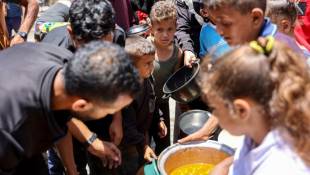 Des Palestiniens font la queue le 17 juin 2024 pour recevoir de la nourriture dans une école de l'agence de l'ONU pour les réfugiés palestiniens (Unrwa) dans le camp de Jabalia, dans le nord de la bande de Gaza ( AFP / Omar AL-QATTAA )