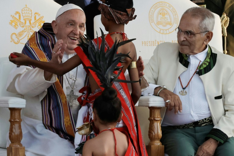 Le pape François salue des jeunes en tenue traditionnelle sous le regard du président du Timor oriental, José Ramos-Horta, lors d'une cérémonie de bienvenue au palais présidentiel de Dili, le 9 septembre 2024 ( POOL / Yasuyoshi CHIBA )