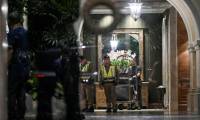Des policiers dans le hall d'entrée d'un hôtel après la découverte de six corps, le 16 juillet 2024 à Bangkok, en Thaïlande ( AFP / Lillian SUWANRUMPHA )