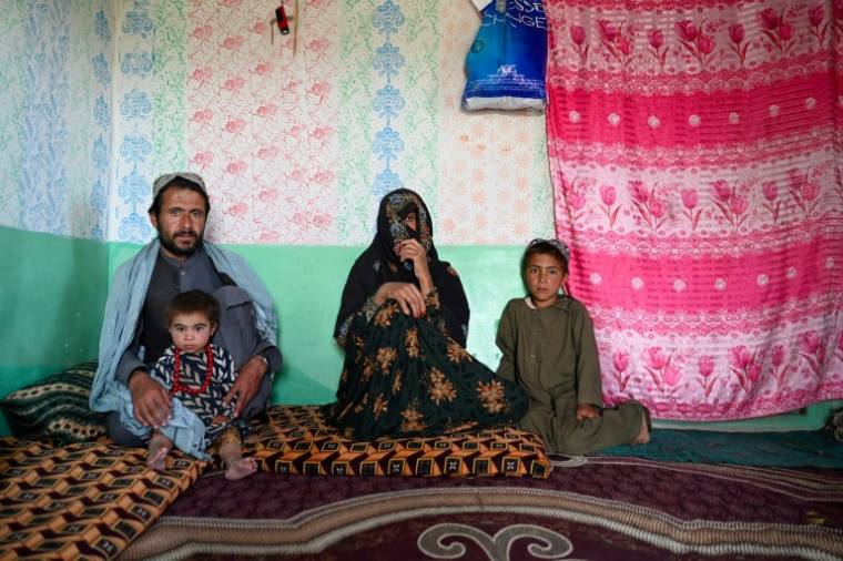 Shawoo (c), la mère de Javid, tué par une munition non explosée, assise avec son mari Sardar Khan (g) et leurs enfants Meena (2e g) et Zubair Ahmad (d), lors d'une interview avec l'AFP à Nokordak, dans la province de Ghazni, le 13 mai 2024 en Afghanistan ( AFP / Wakil KOHSAR )