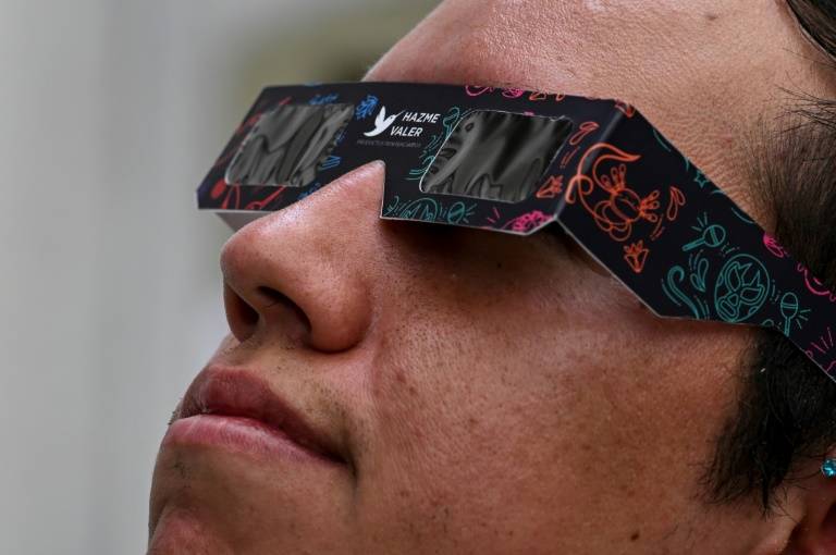 Un employé de l'administration mexicaine chargée de la sécurité des citoyens fait une démonstration de lunettes spécialement conçues pour regarder une éclipse, le 4 avril 2024 à Mexico ( AFP / Yuri CORTEZ )