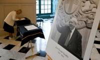 Une femme signe un livre de condoléances près du portrait de l'ancien maire Jean-Claude Gaudin, décédé, le 20 mai 2024 à la mairie de Marseille ( AFP / Nicolas TUCAT )