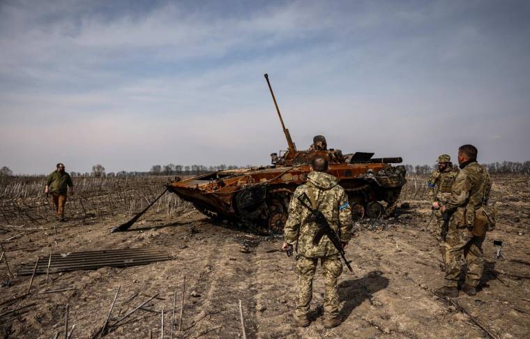 Des soldats ukrainiens devant un tank russe détruit, dans la région de Kiev (illustration) ( AFP / RONALDO SCHEMIDT )