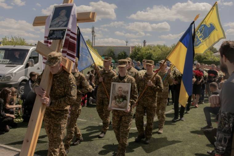 Des soldats portant des portraits de Nazary Gryntsevych, un soldat ukrainien emblématique tué au combat, lors de ses funérailles el 10 mai 2024 à Vinnytsia, en Ukraine ( AFP / Roman PILIPEY )