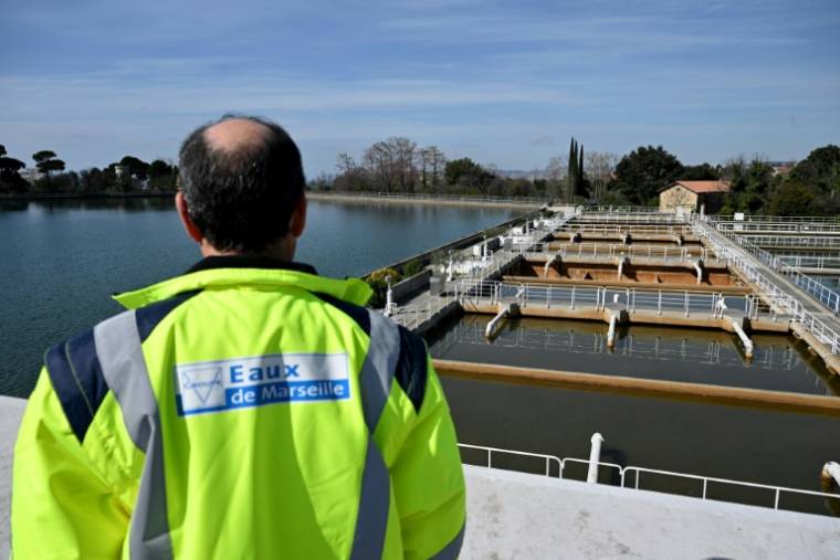 Un employé inspecte les bassins du centre de production d'eau potable de Sainte-Marthe, le 15 mars 2024 à Marseille ( AFP / Nicolas TUCAT )