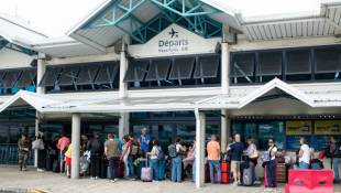 Des passagers attendent d'embarquer à l'aéroport de Magenta le 5 juin 2024 à Nouméa ( AFP / Delphine Mayeur )