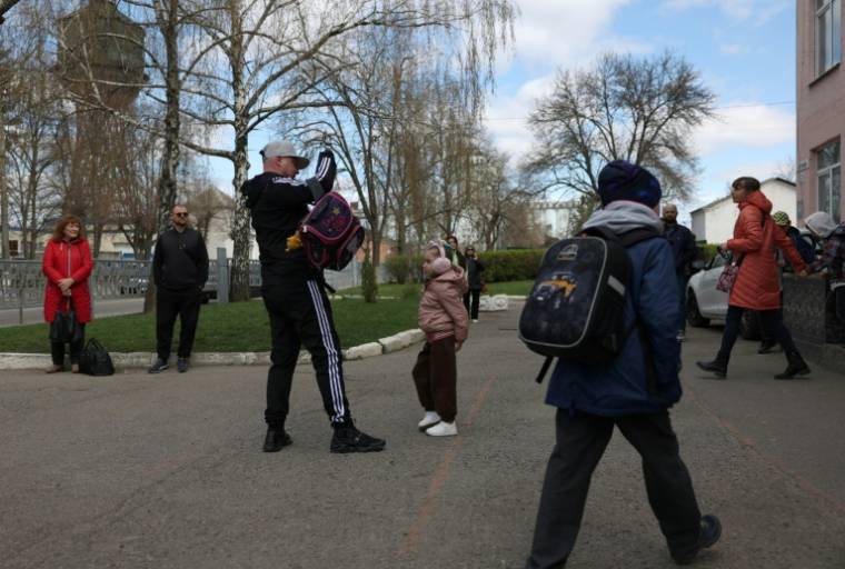 Le sergent ukrainien Valeriï Koutcherenko vient chercher sa fille Valeria à la sortie de l'école, le 4 avril 2024 à Bila Tserkva, au sud de Kiev ( AFP / Anatolii STEPANOV )