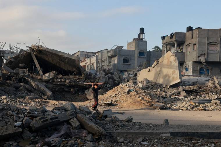 Un garçon marche parmi les décombres des bâtiments détruits lors des frappes israéliennes à Rafah, dans le sud de la bande de Gaza, le 12 décembre 2023 ( AFP / MOHAMMED ABED )