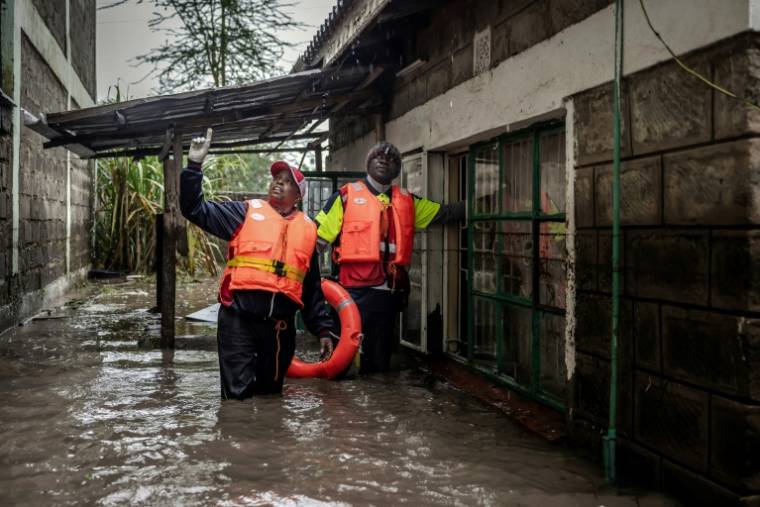 Des membres de la Croix-Rouge recherchent dans une zone inondée des habitants piégés dans leurs maisons après des pluies torrentielles à Kitengela, le 1er mai 2024 au Kenya ( AFP / LUIS TATO )