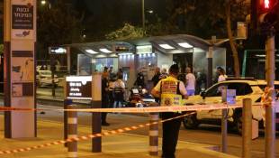 Des policiers et ambulanciers entourent un blessé allongé sur le sol après une attaque au couteau à une station de tramway, le 21 septembre 2023 à Jérusalem ( AFP / AHMAD GHARABLI )