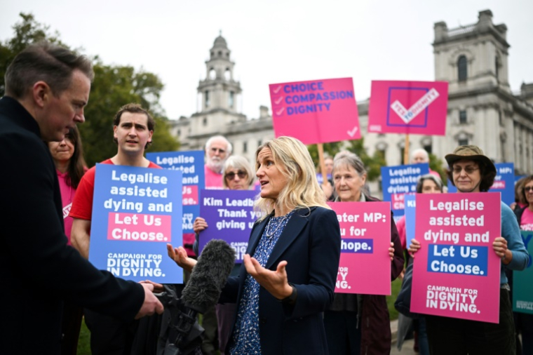 La députée travailliste Kim Leadbeater s'exprime devant la presse, avec des militants de l'association Dignity in Dying (Dignité face à la mort) rassemblés devant le Parlement ( AFP / JUSTIN TALLIS )