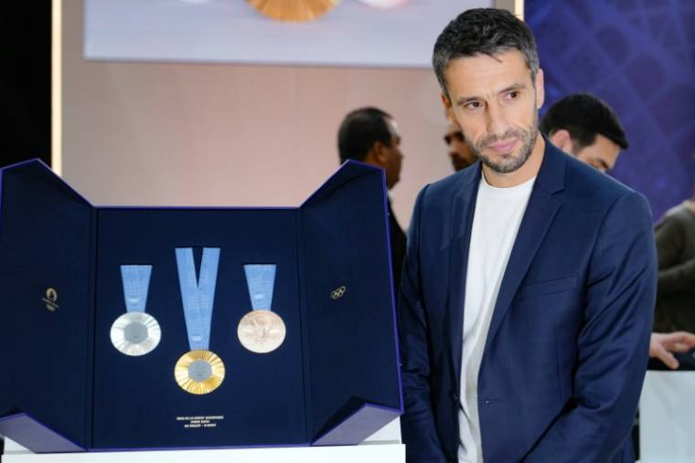 The president of the Organizing Committee for the Paris 2024 Olympic and Paralympic Games (Cojo), Tony Estanguet, poses next to the Olympic medals, unveiled in Paris on February 8, 2024. (AFP / Dimitar DILKOFF)