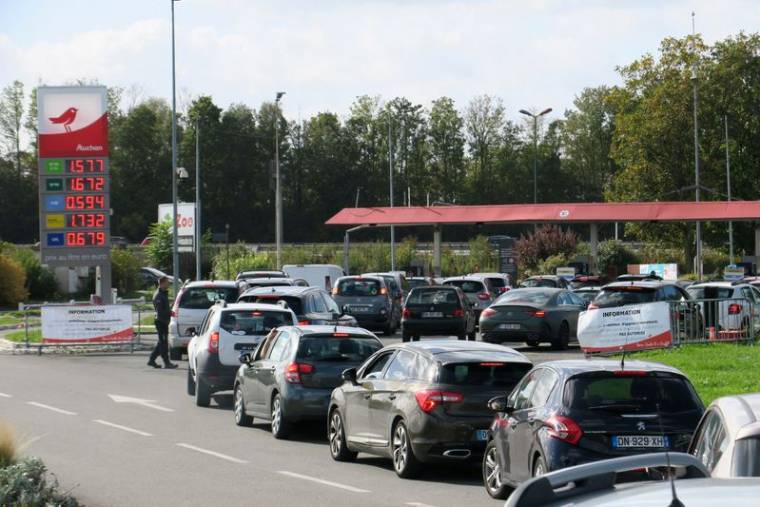 Des automobilistes font la queue pour remplir leur réservoir d'essence aux pompes de la station-service Auchan de Petite-Forêt