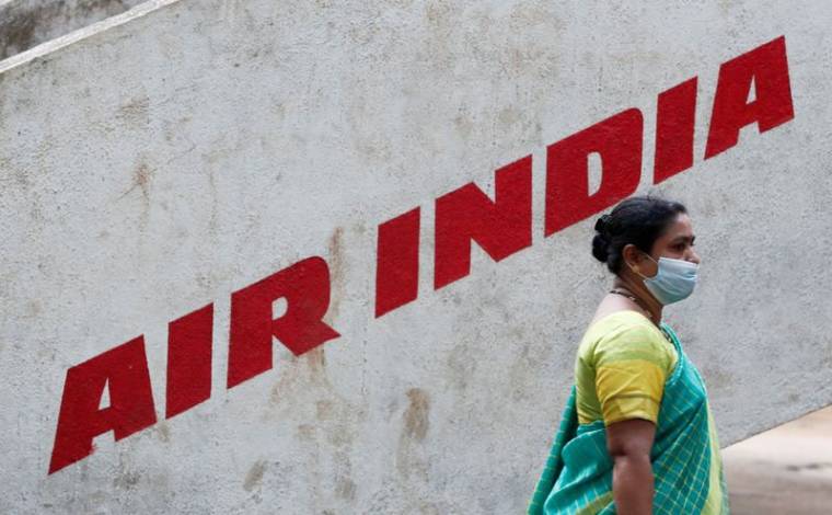 Photo d'archives: Une femme passe devant le logo d'Air India dans un parc de Bonbay