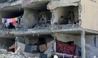 Une famille palestinienne dans une pièce détruite par une frappe israélienne à Rafah, dans le sud de la bande de Gaza, le 22 mai 2024  ( AFP / Eyad BABA )